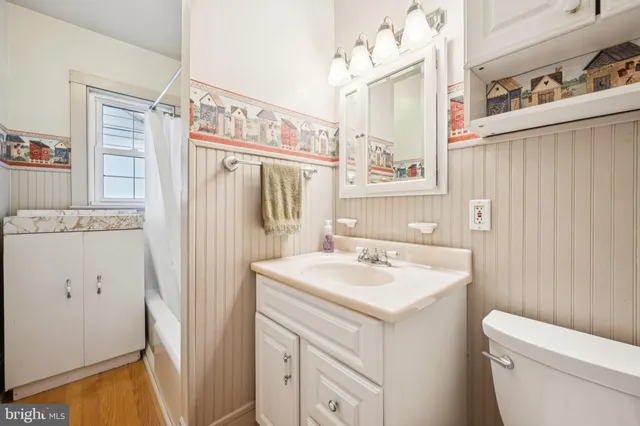 a bathroom with a sink a toilet a mirror a vanity and shower