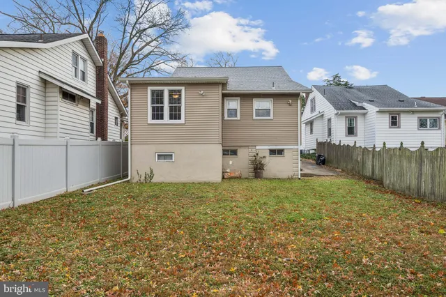 a view of a house with a yard and large tree