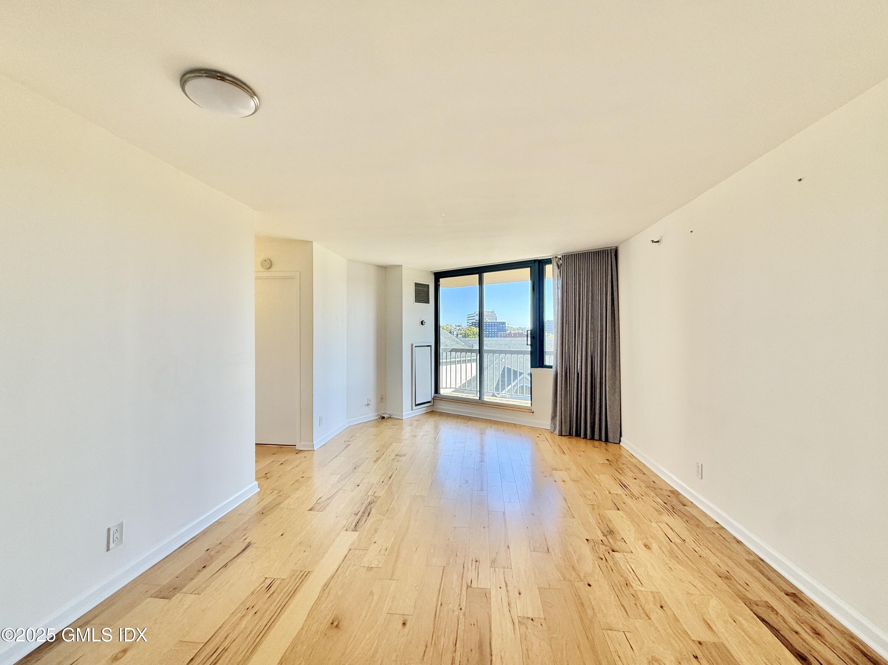 25 Forest Street, Unit 8C Stamford, CT 06901 - Photo 4 of 25 a view of an empty room with wooden floor and a window