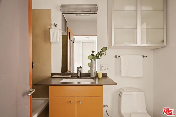 a bedroom with a bed a mirror and a window