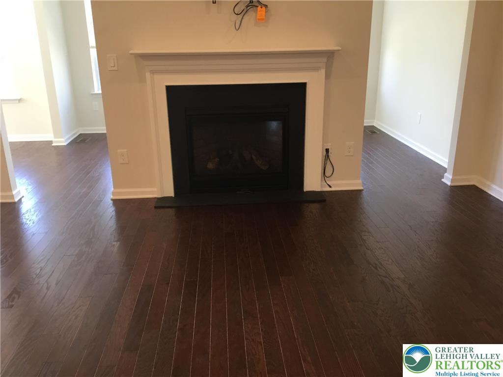 4088 Eveningstar Road Emmaus, PA 18049 - Photo 70 of 78 a view of an empty room with wooden floor and a fireplace