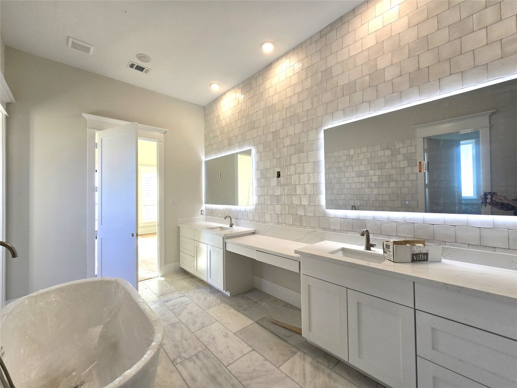 15408 Highlander Court Montgomery, TX 77356 - Photo 21 of 35 a spacious bathroom with a double vanity sink a mirror and a bathtub
