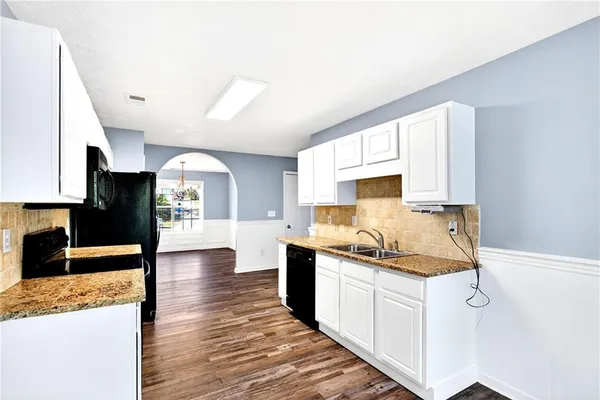 a kitchen with granite countertop a sink and cabinets