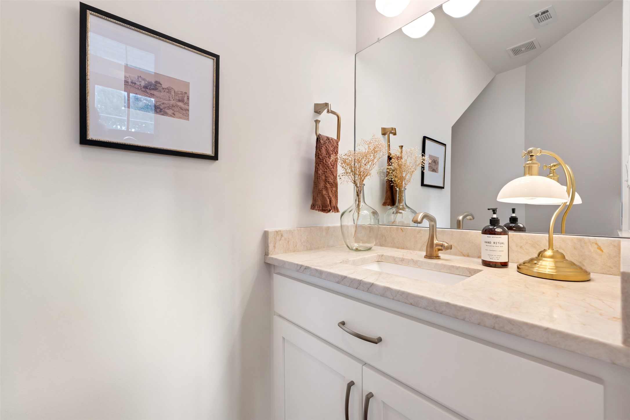 1301 West Street Georgetown, TX 78626 - Photo 28 of 40 A well-lit bathroom vanity features a broad mirror, elegant countertop, and contemporary sink.