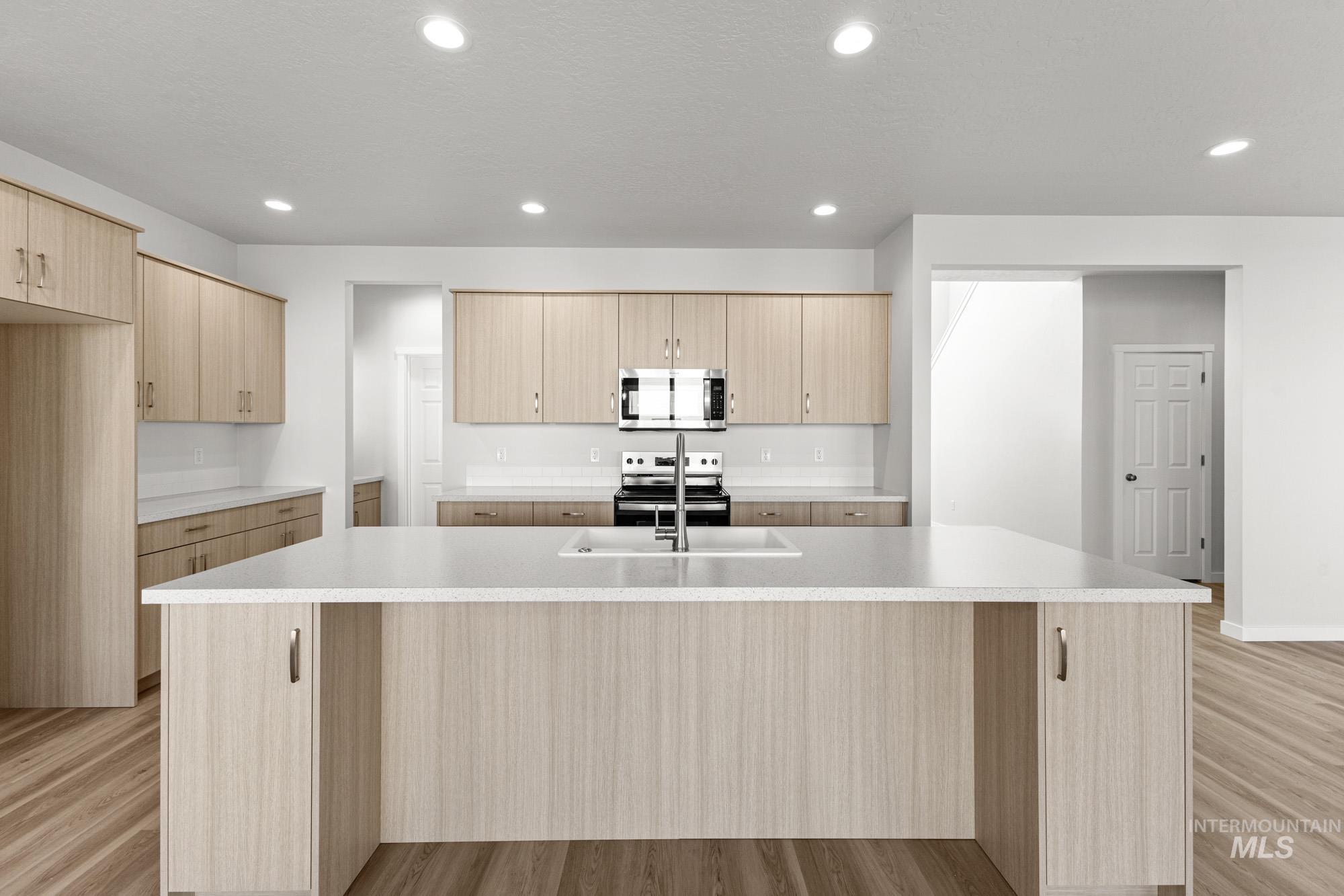 13708 Judson Street Caldwell, ID 83607 - Photo 3 of 29 Kitchen featuring light wood finish cabinets, stainless steel appliances, light wood-style flooring, a center island with sink, and recessed lighting