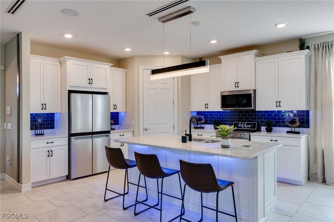 16549 Timber Lane Punta Gorda, FL 33982 - Photo 13 of 30 a kitchen with stainless steel appliances a refrigerator sink and microwave