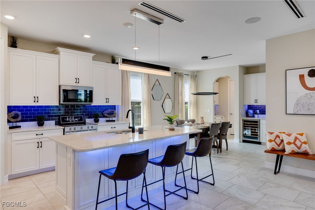 16549 Timber Lane Punta Gorda, FL 33982 - Photo 15 of 30 a kitchen with stainless steel appliances kitchen island granite countertop a table chairs sink and cabinets