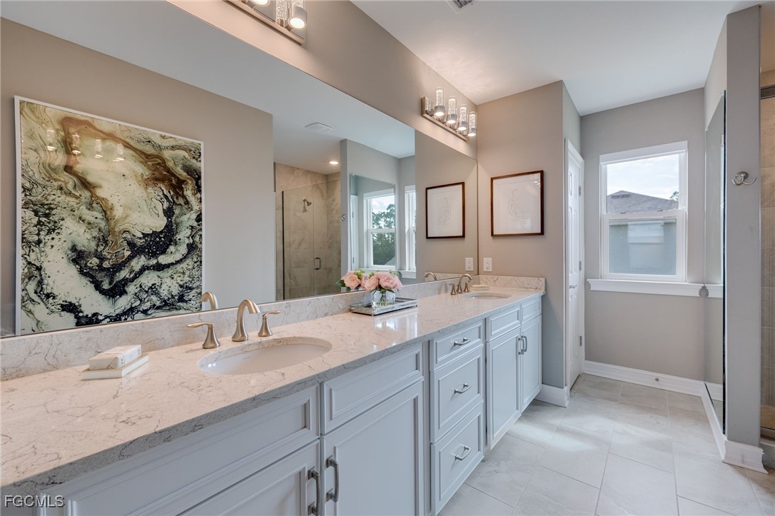 16549 Timber Lane Punta Gorda, FL 33982 - Photo 18 of 30 a bathroom with double vanity sinks a large mirror and a window