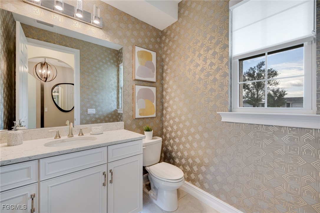 16549 Timber Lane Punta Gorda, FL 33982 - Photo 27 of 30 a bathroom with a toilet a sink and a mirror