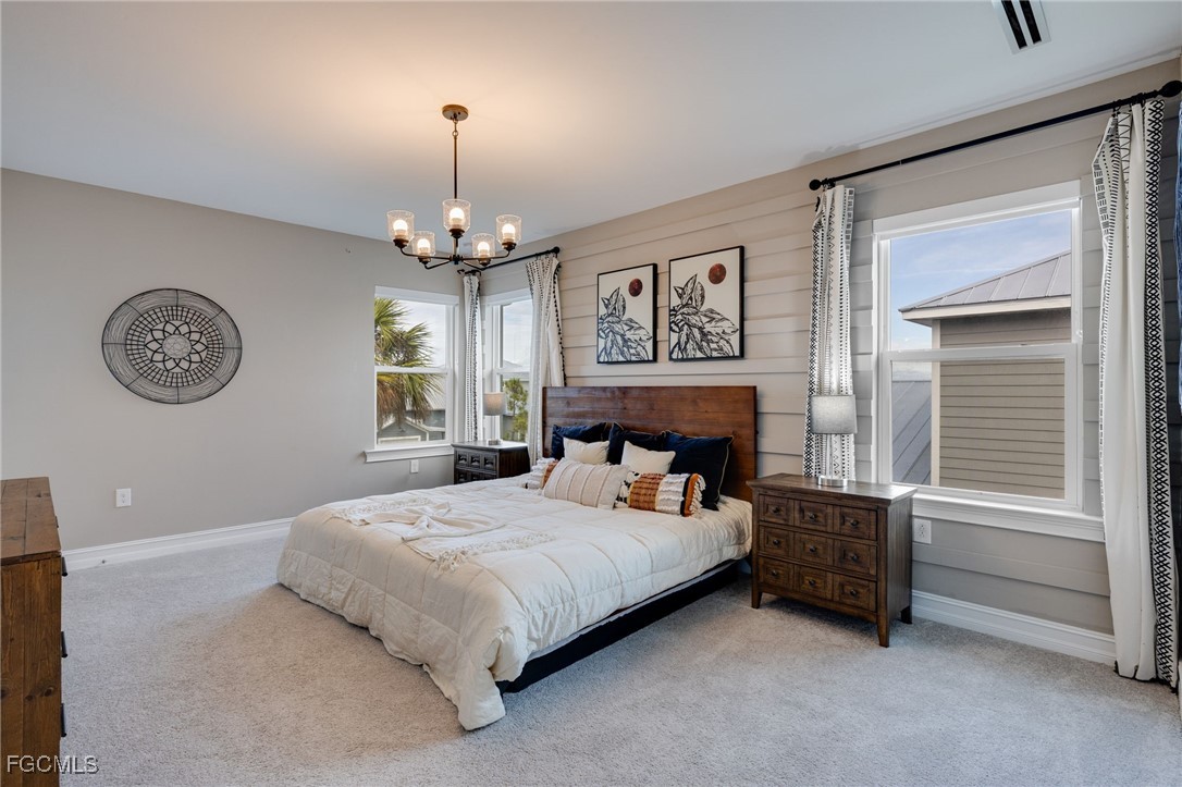 16549 Timber Lane Punta Gorda, FL 33982 - Photo 3 of 30 a bedroom with a bed and a chandelier