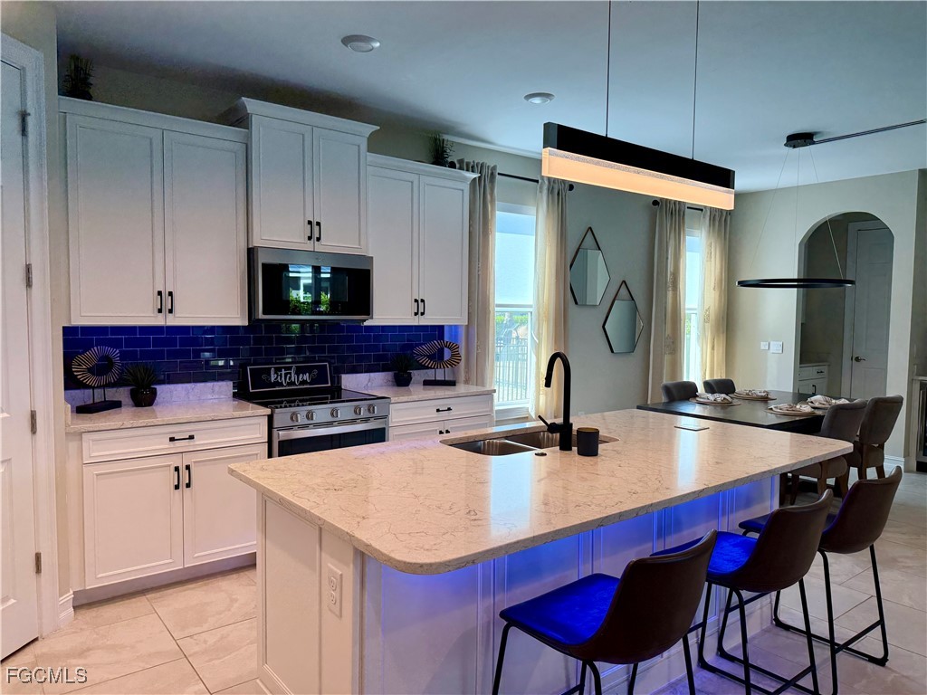16549 Timber Lane Punta Gorda, FL 33982 - Photo 6 of 30 a kitchen with sink a microwave and cabinets