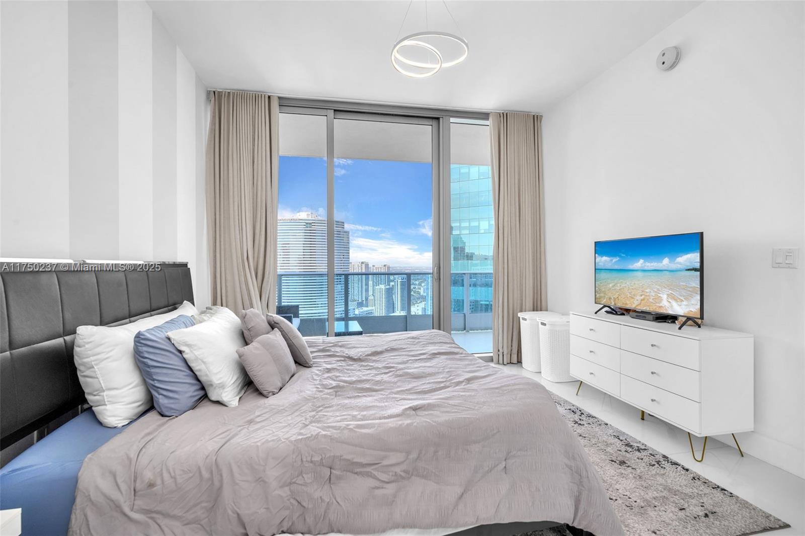 200 Biscayne Blvd Way, Unit 4910 Miami, FL 33131 - Photo 13 of 26 a bedroom with a bed and a flat screen tv