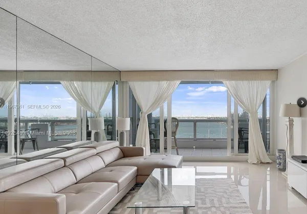 a living room with furniture a large window and flat screen tv