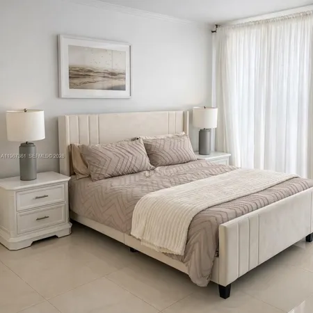 a bedroom with a bed and a lamp on dresser