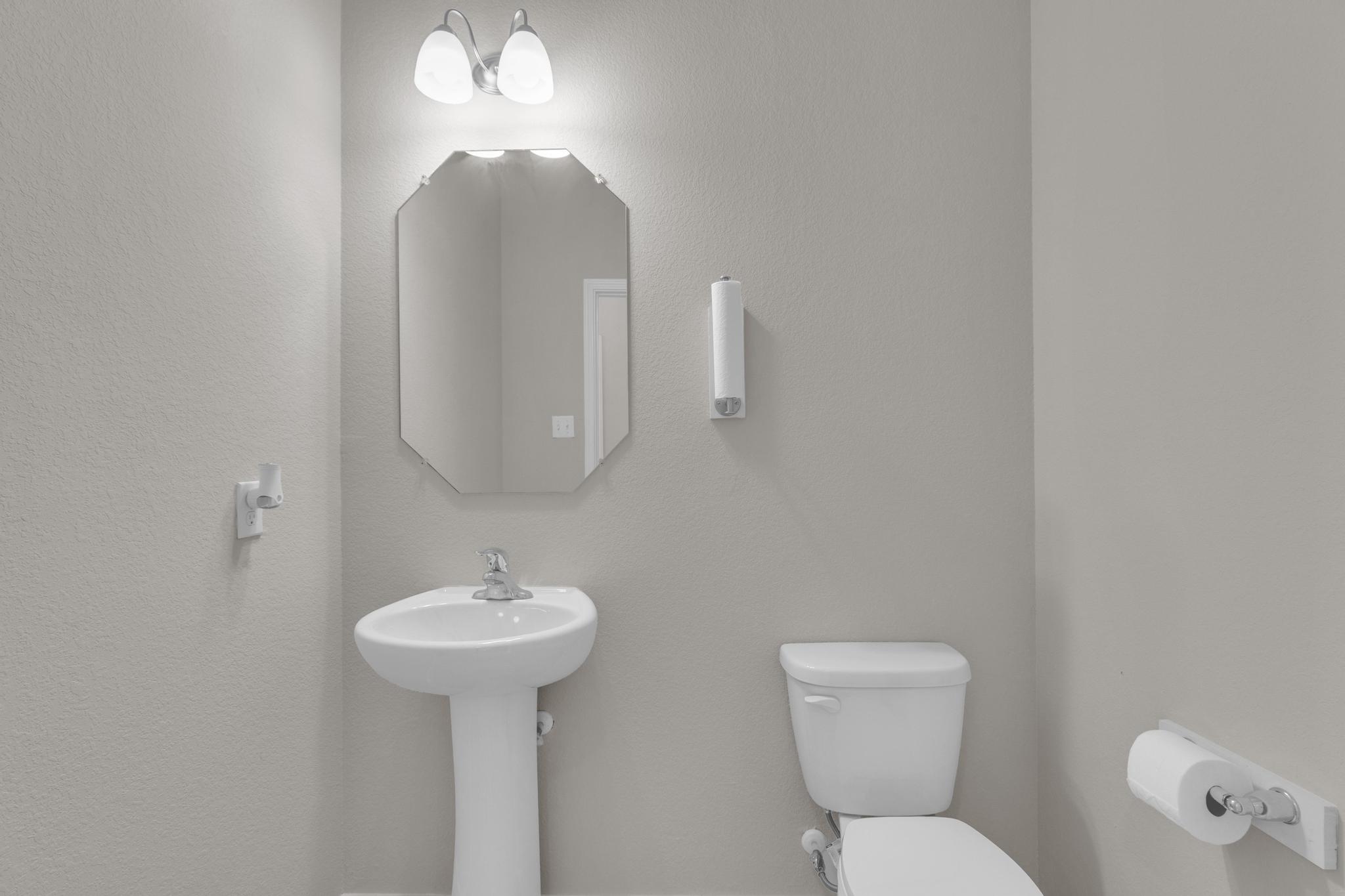 104 Uncle Billy Way Jarrell, TX 76537 - Photo 8 of 38 A compact and pristine powder room, offering essential amenities with a clean, modern aesthetic.