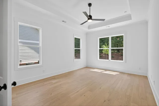 a view of an empty room with a window and wooden floor