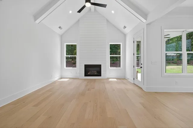 en empty room with windows and fireplace