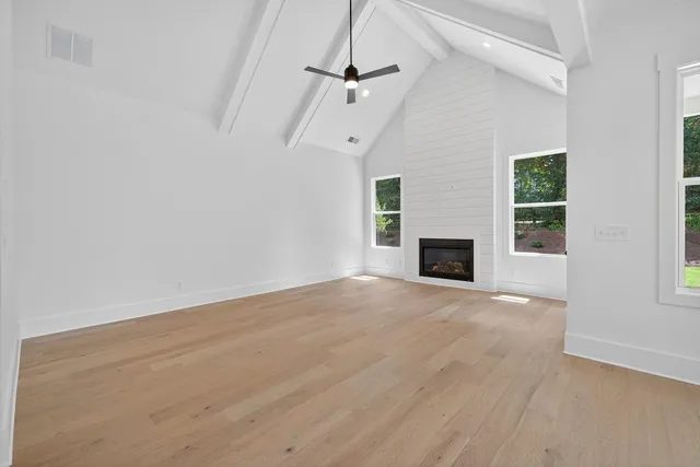 an empty room with windows and a fireplace