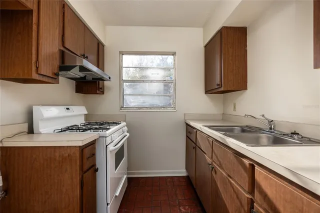 a kitchen with stainless steel appliances granite countertop a sink stove and cabinets