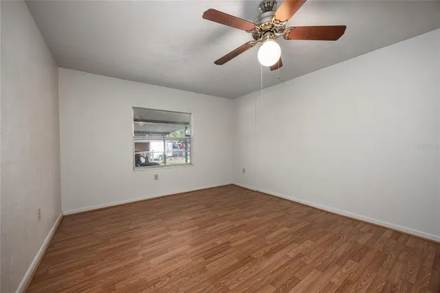 wooden floor in an empty room with a window