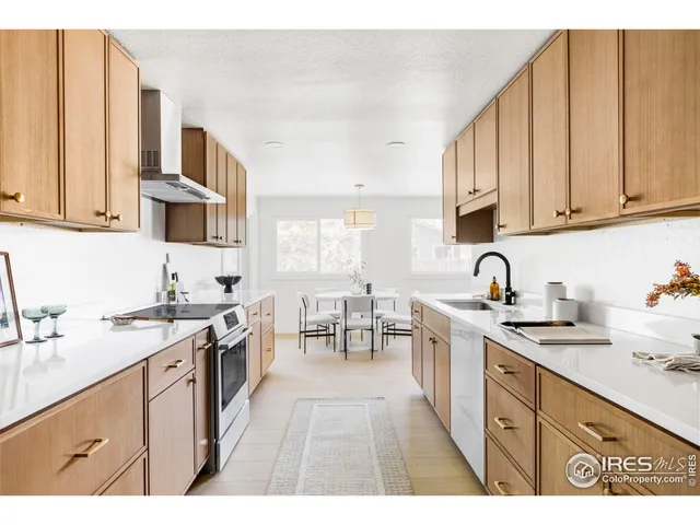 a kitchen with stainless steel appliances granite countertop a stove a sink dishwasher and cabinets with wooden floor