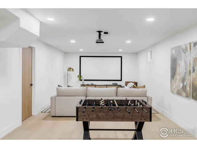 a living room with furniture a large window and a projector