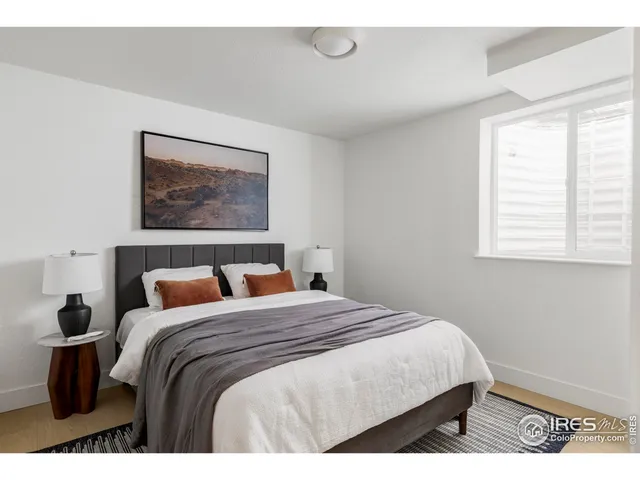 a bedroom with a bed and a painting on the wall