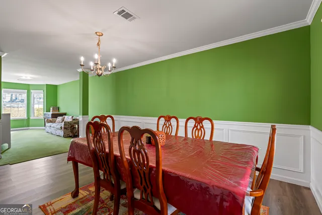a kitchen with stainless steel appliances kitchen island granite countertop a refrigerator and chairs