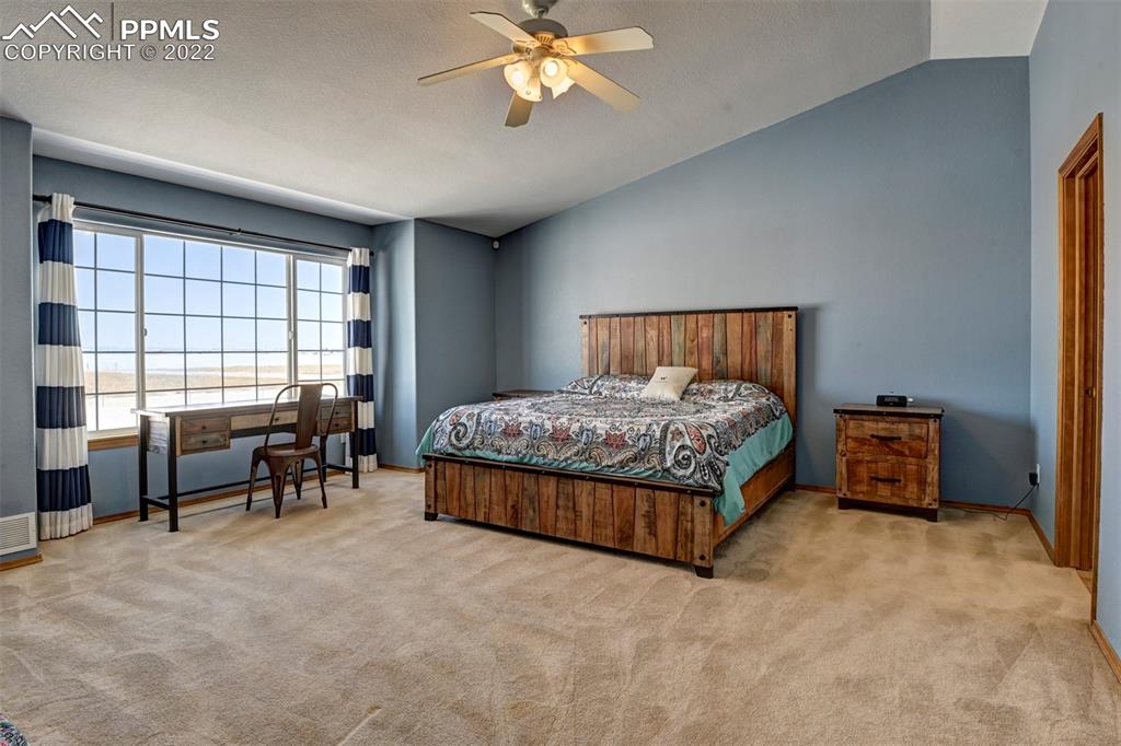31550 Sanborn Road Yoder, CO 80864 - Photo 30 of 50 a bedroom with a bed and a chandelier