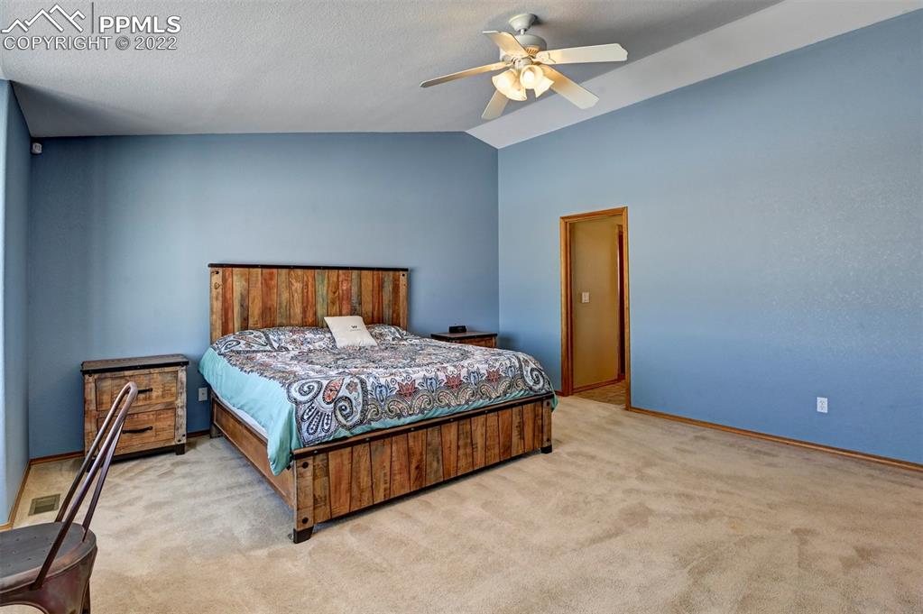 31550 Sanborn Road Yoder, CO 80864 - Photo 32 of 50 a bedroom with a bed and a chandelier