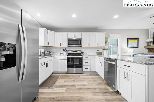 a kitchen with granite countertop a refrigerator stove and sink