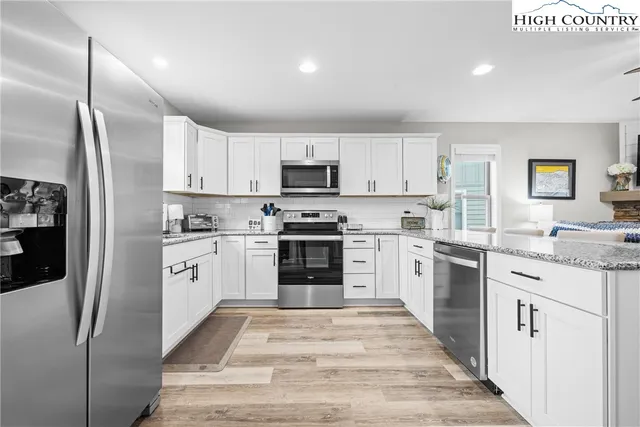 a kitchen with granite countertop a refrigerator stove and sink