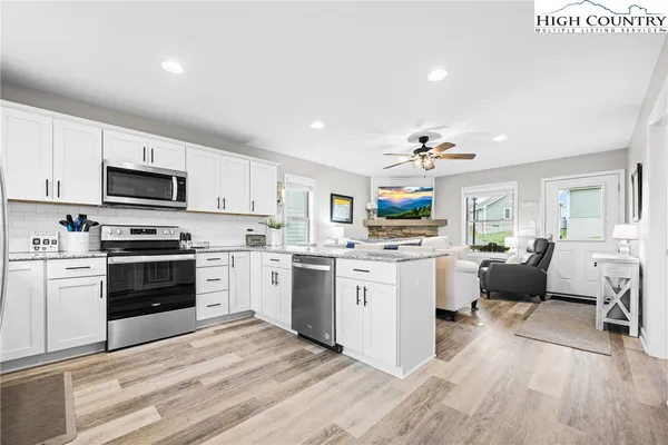 a kitchen with white cabinets and stainless steel appliances