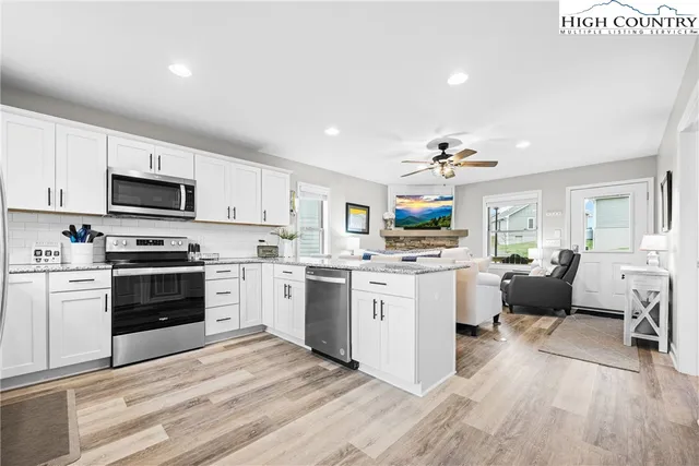 a kitchen with white cabinets and stainless steel appliances