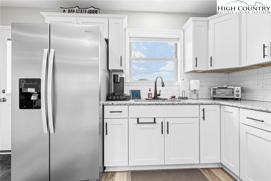 513 Townhomes Place, Unit 27 Boone, NC 28607 - Photo 14 of 33 a kitchen with white cabinets and refrigerator
