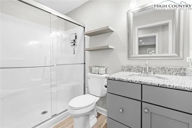 a bathroom with a granite countertop sink toilet and shower