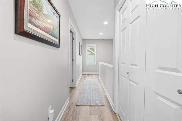 a view of a hallway with wooden floor and entryway