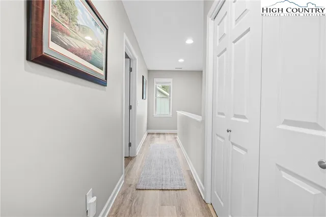 a view of a hallway with wooden floor and entryway
