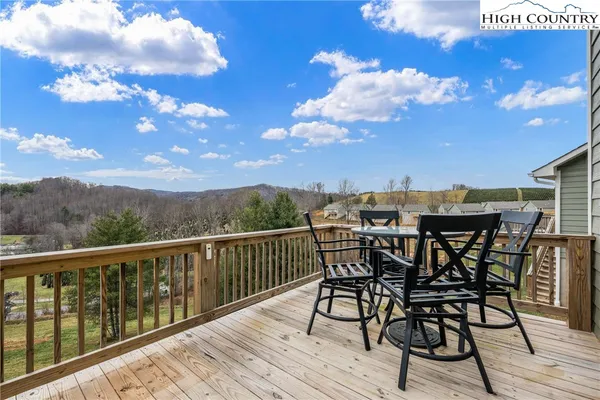 a view of a roof deck with table and chairs with wooden floor