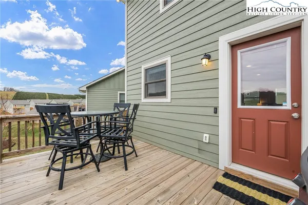 a view of a roof deck with table and chairs with wooden floor and fence