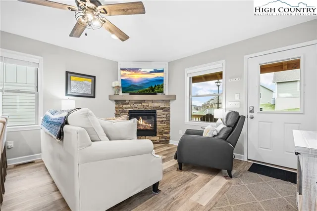 a living room with furniture a flat screen tv and a fireplace
