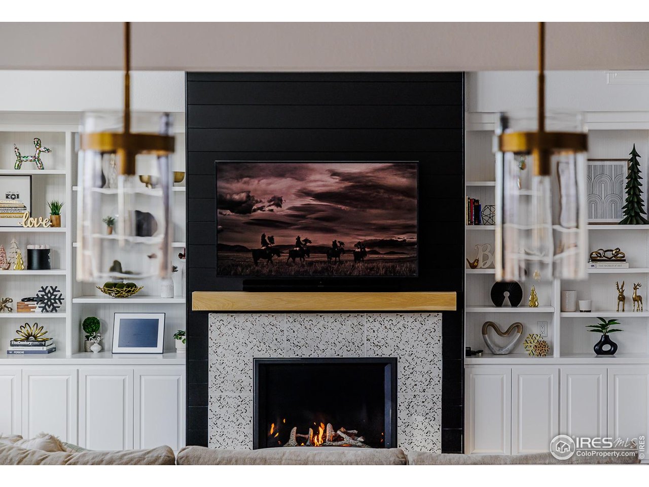 7401 Deerfield Road Longmont, CO 80503 - Photo 9 of 49 Gas fireplace in living room with built-in storage and display options