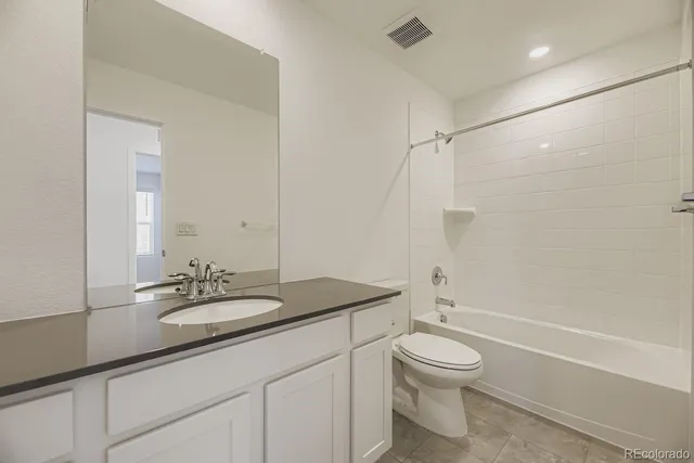a bathroom with a granite countertop sink toilet a mirror and shower