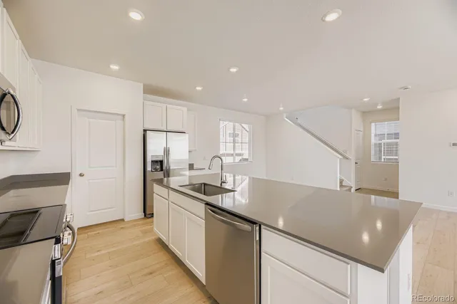 a kitchen with stainless steel appliances granite countertop a sink stove and refrigerator