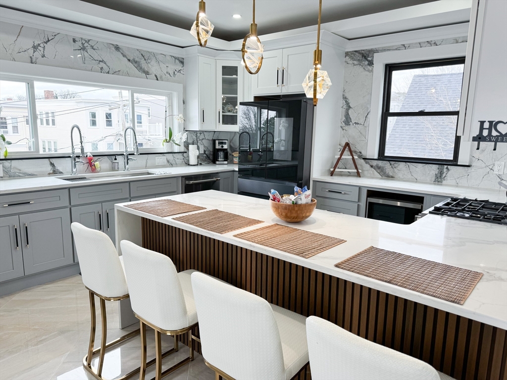 31 Train Street, Unit 3FURNISHED Boston, MA 02122 - Photo 6 of 17 a kitchen with stainless steel appliances kitchen island granite countertop a sink and white cabinets