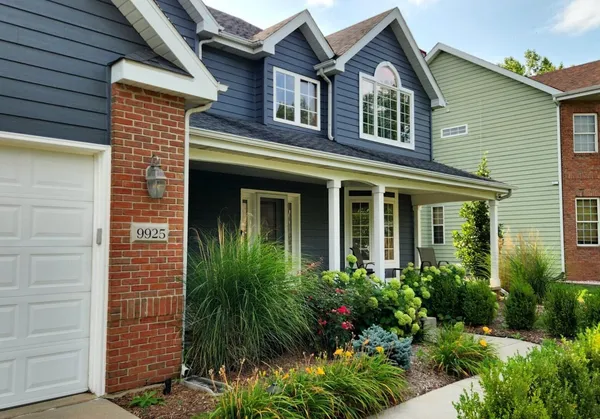 a front view of a house with plants