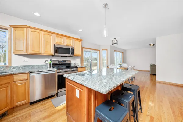 a kitchen with stainless steel appliances granite countertop sink stove top oven and cabinets