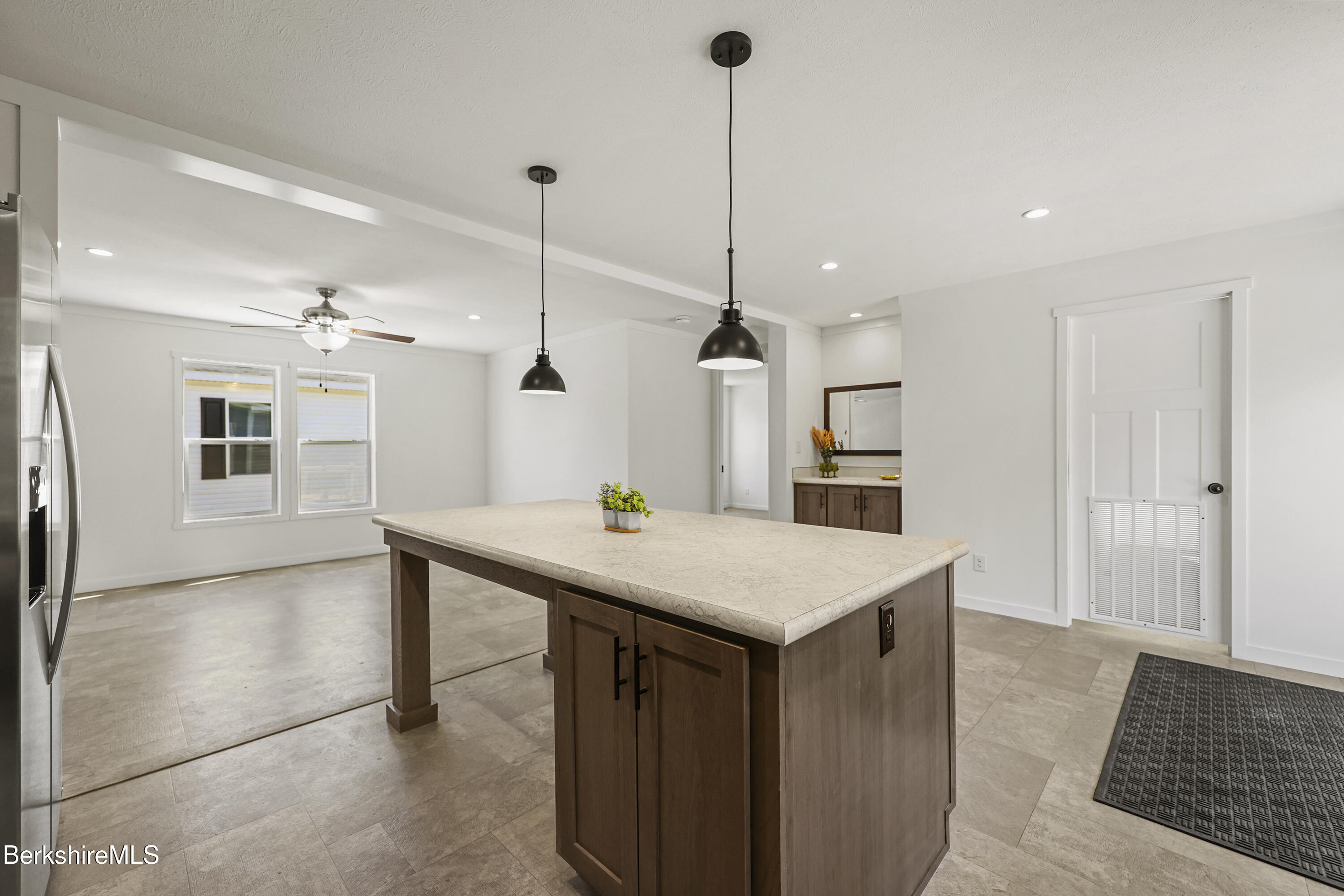 395 Cheshire Road, Unit 112 Pittsfield, MA 01201 - Photo 13 of 32 a kitchen with a table a refrigerator and cabinets