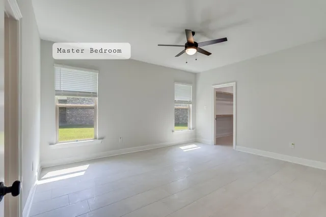 a spacious bedroom with a bed a chandelier and a potted plant