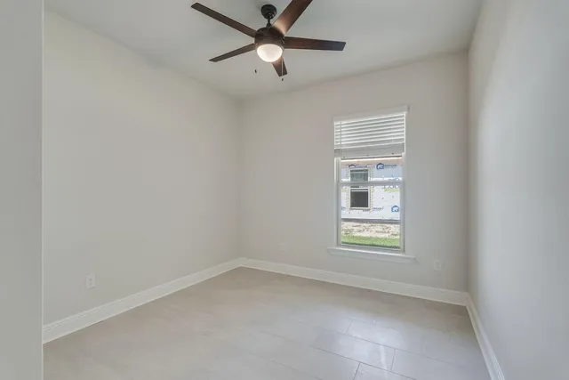 an empty room with closet and ceiling fan
